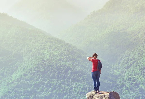 Wanderin steht bei Sonnenaufgang auf dem Felsen — Stockfoto