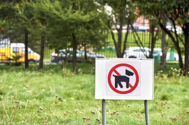 Sign prohibiting dogs walking on the lawn clipart