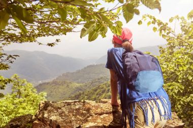 Uzun yürüyüşe çıkan kimse kız yüksek uçurumdan aşağı bakıyor