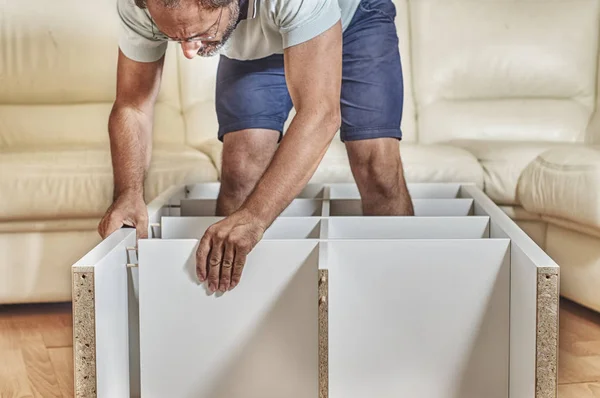 Man assembling a shelving at home — Stock Photo, Image