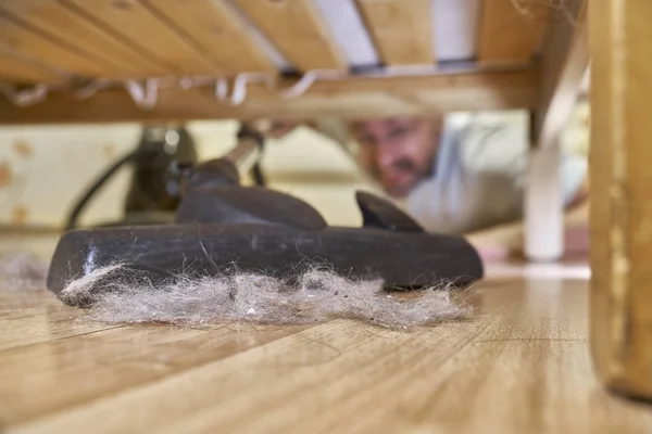 Vacuuming floor under a bed — Stock Photo, Image