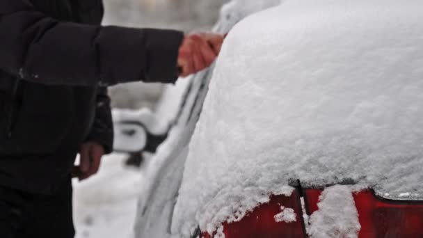 Mann räumt nach starkem Schneesturm Schnee aus Auto — Stockvideo