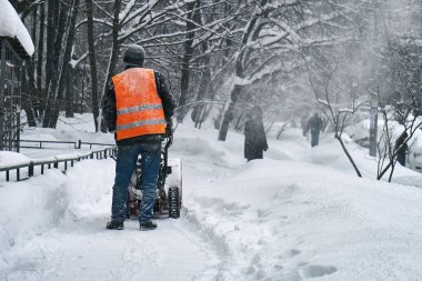 Belediye işçisi kar kar üfleyici kullanarak Moskova sokaktan kaldırma