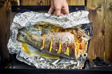 Kızlar el elektrikli fırın dan taze pişmiş bir alabalık yaptırmayı