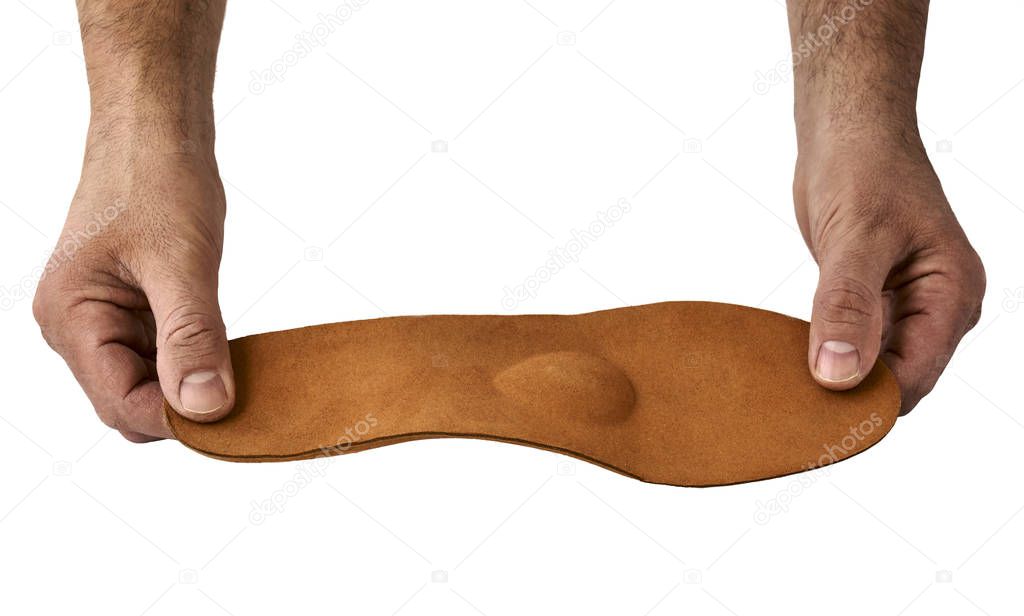 Orthopedic insole in male hands isolated on white background
