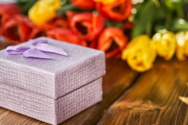 Ön plan ve arka plan bulanık tahta masada yatan taze Lale buketi hediye kutusu.