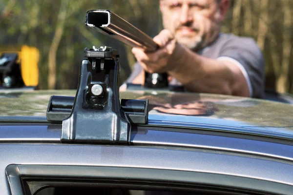 Hombre que instala un estante de techo de coche al aire libre — Foto de Stock