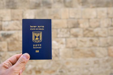 Erkek el, eski Jaffa duvarlı bir İsrail pasaportu tutuyor.