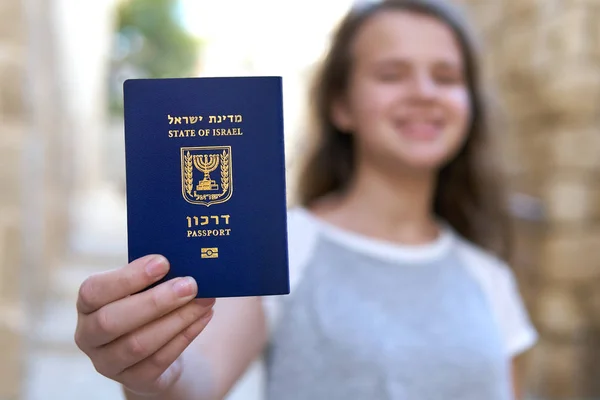 Menina adolescente feliz mostrando o passaporte do Estado de Israel segurando-o na mão — Fotografia de Stock