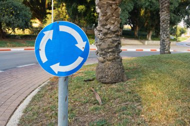 İsrail 'de arka planda palmiye ağacı olan yol işareti dairesel hareket