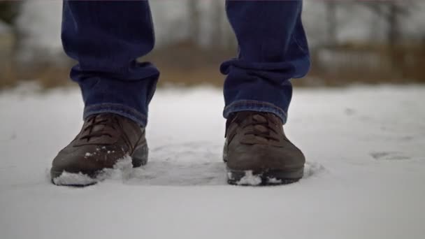 Egy férfi lába, aki megfagy a hidegtől, és lábról lábra mozog. — Stock videók