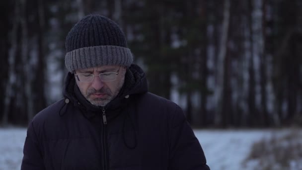 Triste hombre de mediana edad preocupándose por algún problema al aire libre en invierno — Vídeos de Stock