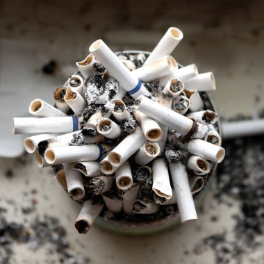 Pencere kenarında duran tütsülenmiş sigaralarla dolu teneke bir kutu. Görünümün üstünde