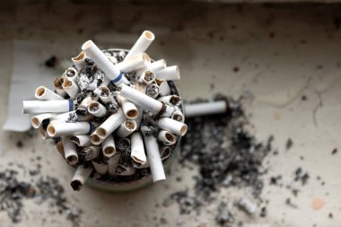 Pencere kenarında duran tütsülenmiş sigaralarla dolu teneke bir kutu. Görünümün üstünde