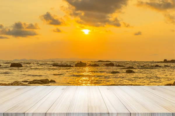 Leerer Holztisch oder Regalwand mit Sonnenuntergang oder Sonnenaufgang auf Sand Stockbild