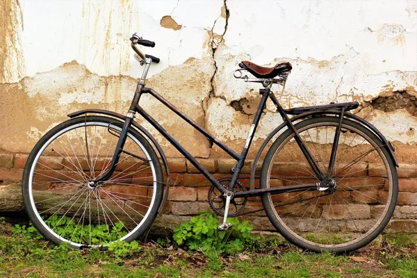 Altes Oldtimer-Fahrrad steht gegen die rissige Wand — Stockfoto