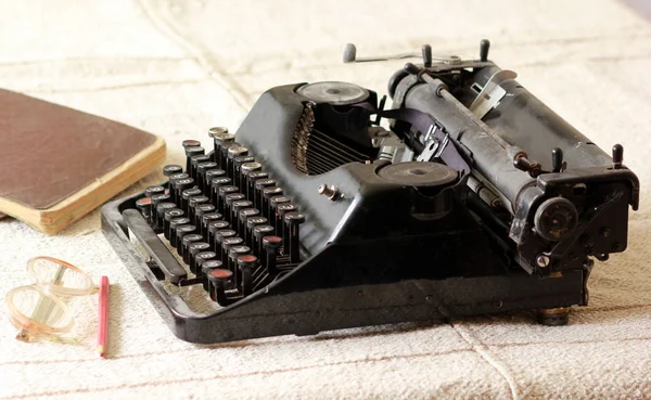 Вінтажна друкарська машинка, окуляри, олівці та блокноти — стокове фото