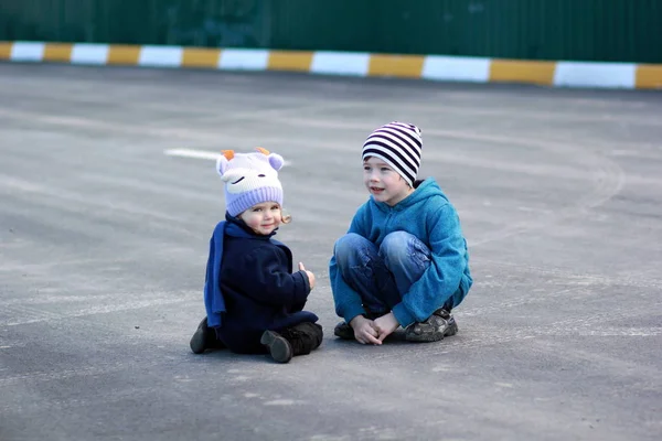 En pojke och en flicka på asfalt. — Stockfoto
