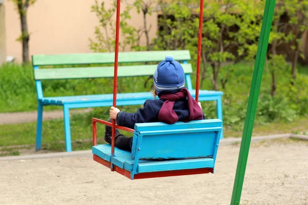 Meisje zittend in de houten kleurrijke swing — Stockfoto