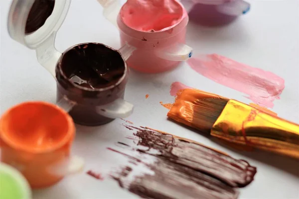 Used open acrylic orange brown pink paints, brush and strokes — Stock Photo, Image