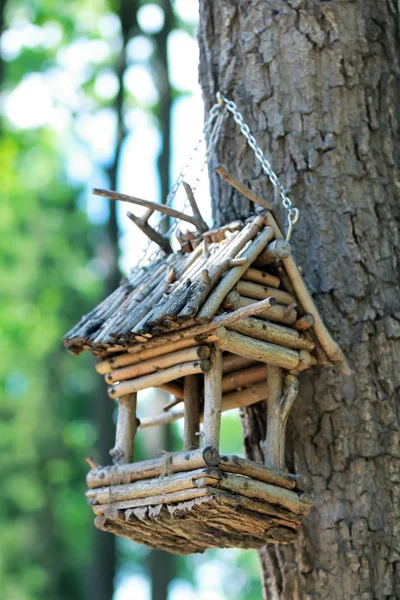 Casa creativa hecha a mano de madera para pájaros / alimentador de aves con dos palomas de pie en un poste en un parque —  Fotos de Stock