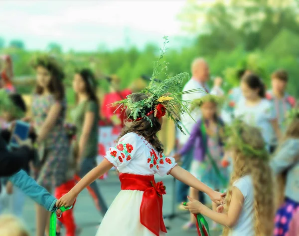 Fiatal lány visel a koszorú és etnikai ukrán ruha tánc egy gyűrű, Ivan Kupala a pogány ünnep ünnepli — Stock Fotó
