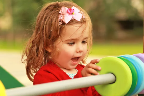 Gelukkig één jaar oud meisje spelen met houten kleurrijke cirkels — Stockfoto