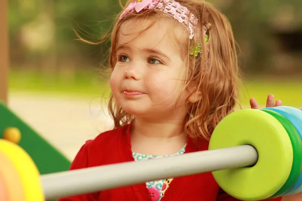 Happy one year old girl playing with wooden colorful circles