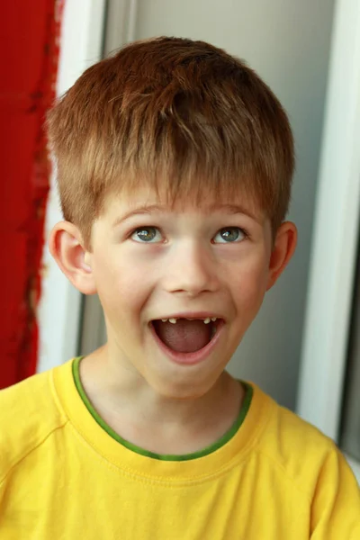 Portret chłopca w żółty T-shirt, którego przednie zęby mleczne top wypadł — Zdjęcie stockowe