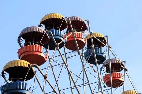 Buntes Riesenrad bewegt sich gegen blauen Himmel im sommerlichen Vergnügungspark — Stockfoto