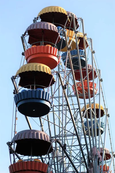 Roda gigante colorida movendo-se contra o céu azul no parque de diversões de verão — Fotografia de Stock