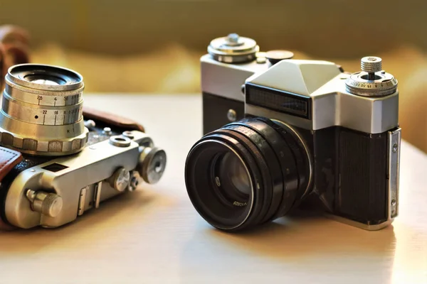 Duas câmaras antigas na mesa castanha clara. Um em couro retro marrom caso titular — Fotografia de Stock