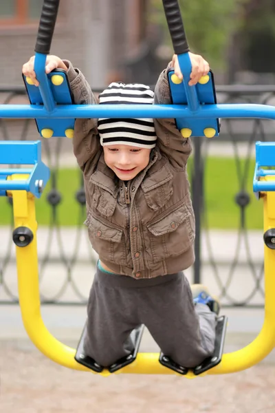 Five year old boy working out in the street, in the outdoor gym in the yard — Stock Photo, Image