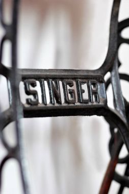 Bir eski Amerikan bağbozumu manuel dikiş makinesi üzerinde metal bir şarkıcı logosunun yakın çekim. 