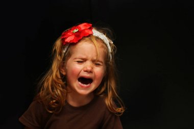 Upset little girl crying out load, portrait isolated on black clipart