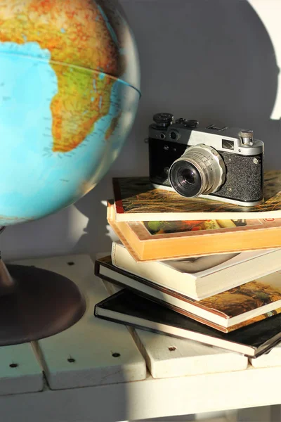 成堆的书 旧的胶卷照相机和白色木桌上的地球仪 旅行的概念 规划梦想的旅行 — 图库照片