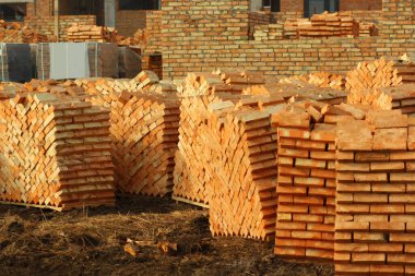 Dışarıda yığınla kırmızı tuğla var. Mimarlık ve inşaat endüstrisi