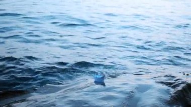 Bir kağıt tekne suya başlatılır. Video.