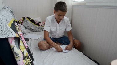 Genç çocuk hazırlar ve bir kağıt uçak oyuncak başlattı