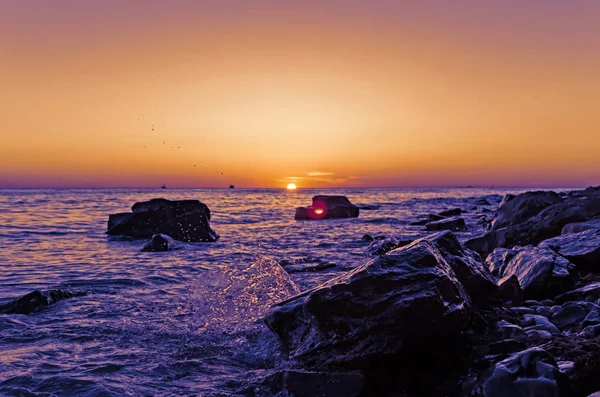 Pôr-do-sol brilhante sob o mar com ondas salpicos . — Fotografia de Stock