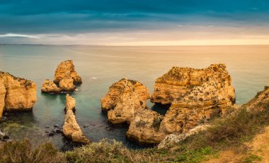 Portekiz 'in Algarve kentindeki Lagos turistik köyü yakınlarında gün batımında Ponta da Piedade kaya oluşumları
