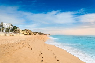 Kumlu sahil ve Albufeira tatil köyündeki oteller Algarve, Portekiz 'de gün batımında.
