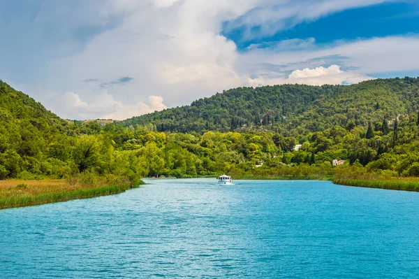 Zelené kopce s lesem kolem řeky Krka s turistickými loděmi v krásném národním parku Krka, Chorvatsko — Stock fotografie