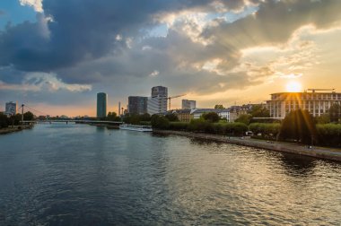 Frankfurt am Main ile Holbeinsteg yaya köprüsü, turistik tekne ve gün batımında ana nehir boyunca gezinti