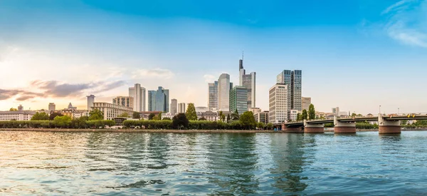 Frankfurt 'un panoramik manzarası. Günbatımında ana nehir üzerinde turistik tekne, gezinti güvertesi ve gökdelenlerle ana gökdelenler.