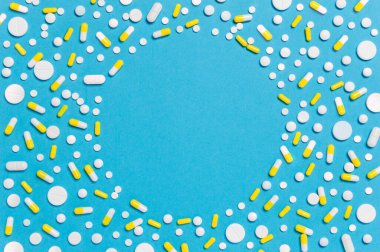 Mavi ilaç ya da tıbbi altyapıya sahip beyaz ve sarı haplar ve kapsüller metin için kopyalama alanı, düz uzanma