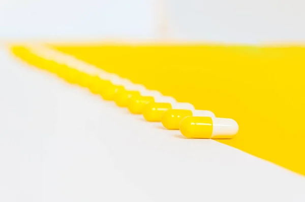 Řada Kapslí Léky Lemované Křižovatce Bílého Žlutého Pozadí Farmaceutické Nebo — Stock fotografie