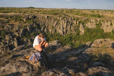 Kanyon cliff üzerinde oturan bir sakallı genç adam