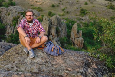 Kanyon cliff üzerinde oturan bir sakallı genç adam