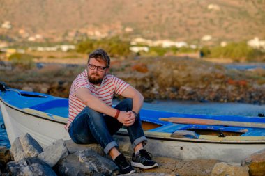 Günbatımı huzurlu an zevk taş üzerine oturan genç adam